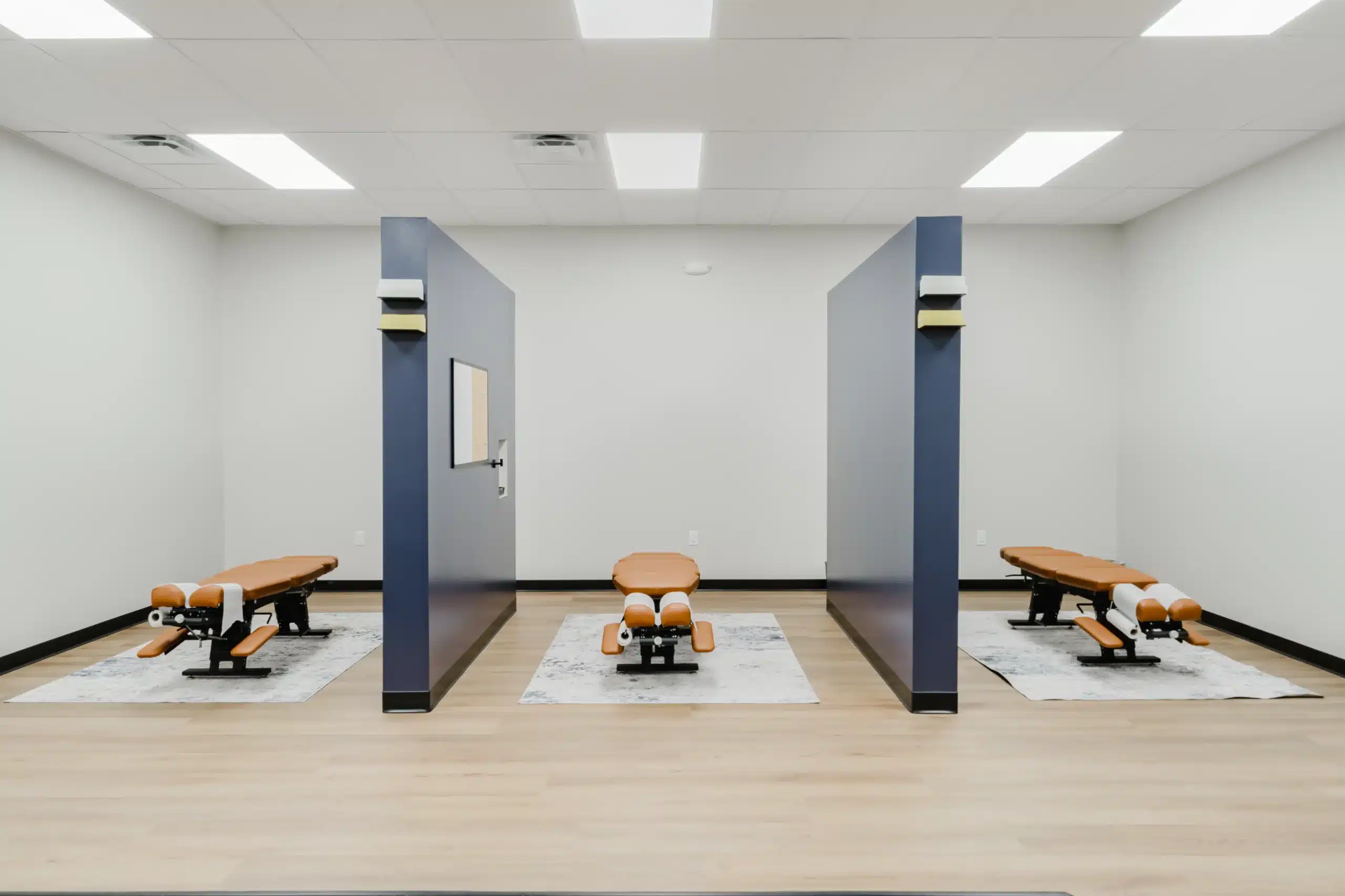 Clean and modern chiropractic treatment area with three adjustment tables, serving patients from a chiropractor in Alliance and chiropractor near Alliance, located in North Fort Worth.